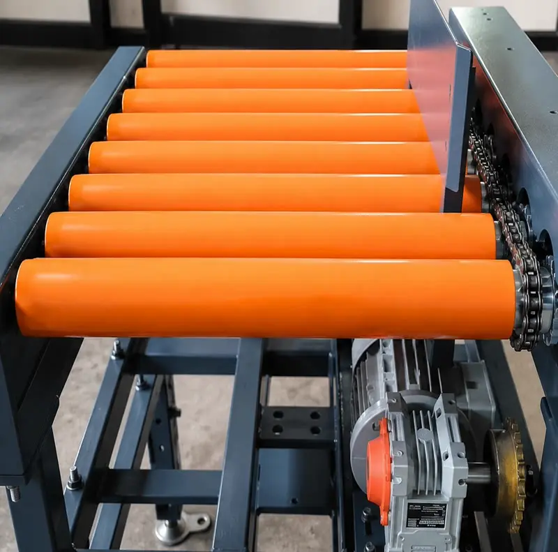 Heavy duty chain driven live roller conveyor handling manufacturing bins inside plant floor